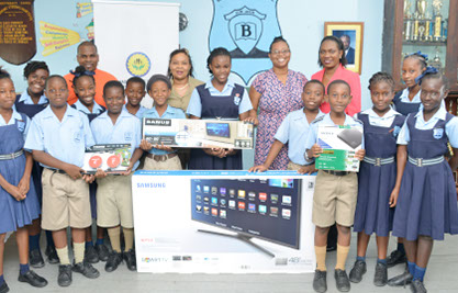 Fabian Chase, I.T. Co-ordinator (L) with students of Belmont Primary School and Director of BPWCCUL, Christina John